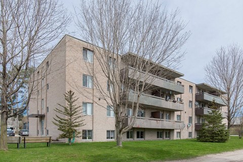 A large apartment building with a grassy area in front.