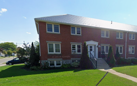 A red brick house with a white door and windows.