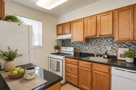 A kitchen with wooden cabinets and a black countertop.