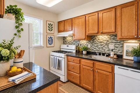 A kitchen with wooden cabinets and a white oven.
