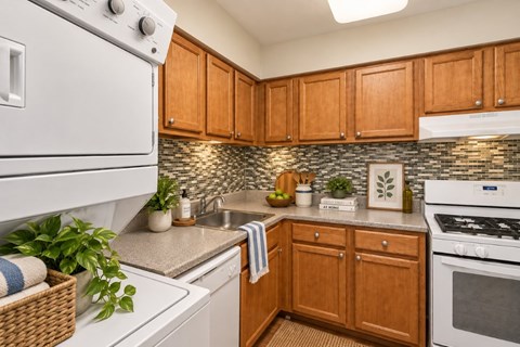 A kitchen with white appliances and wooden cabinets.
