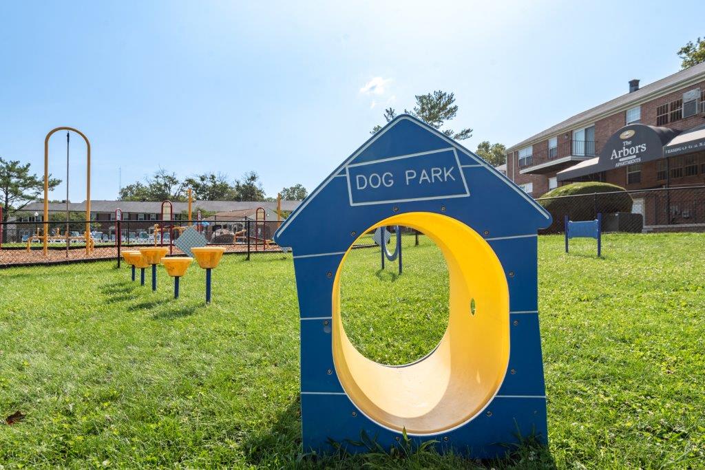 Grassy dog park photo, close up on an agility course shaped like a dog house