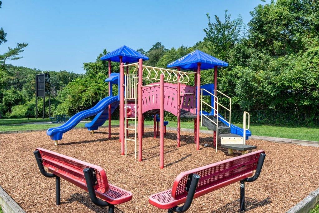 Another view of playground with benches at the front of the photo