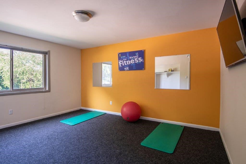 a yoga room with a red ball and yoga mats