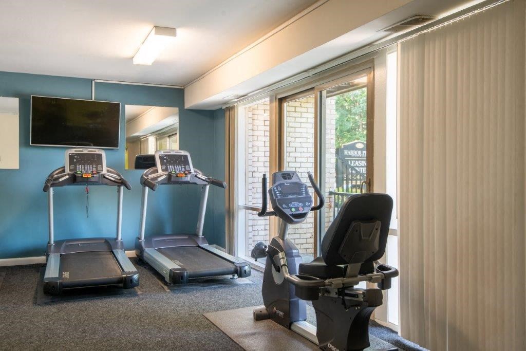 a gym with two treadmills and a tv