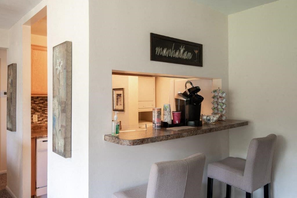 a kitchen with a counter with two chairs and a sink