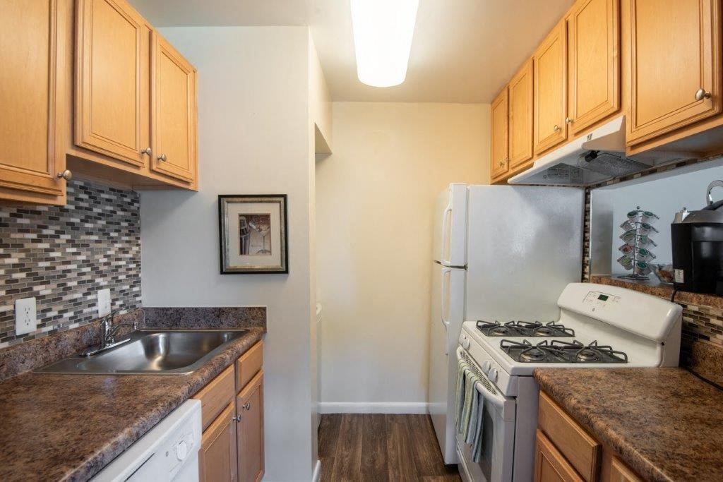 a kitchen with a stove refrigerator and sink