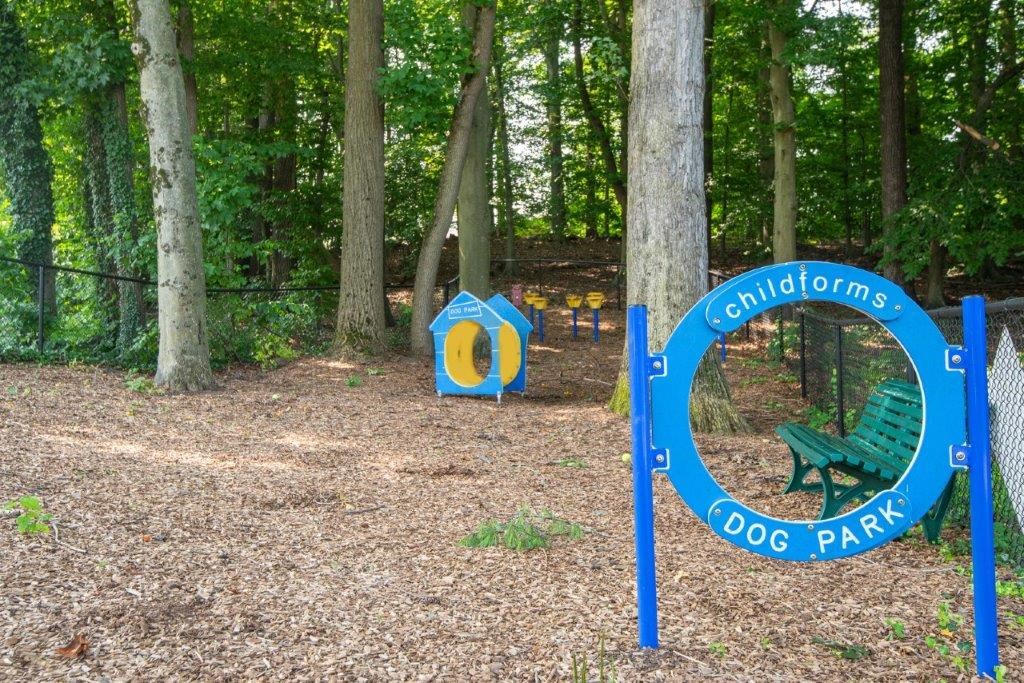 a park with a playground and a blue park sign
