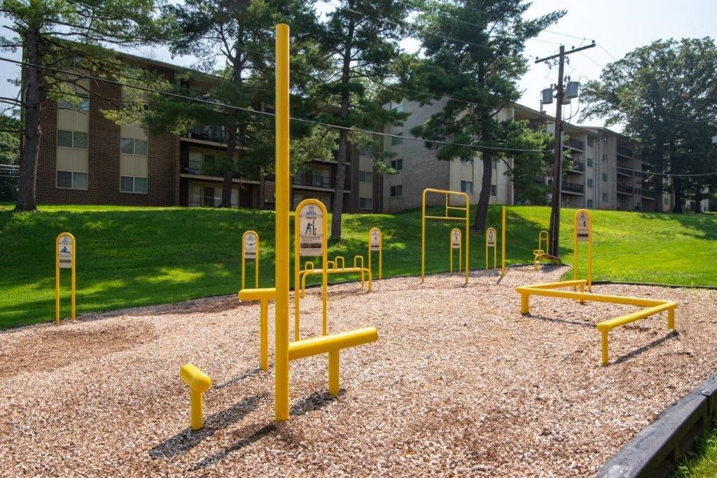 a playground with yellow equipment in front of an apartment building