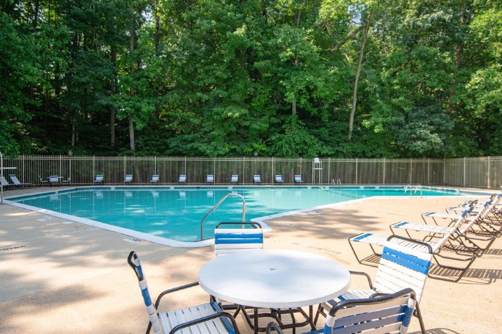 a swimming pool with a table and chairs next to it