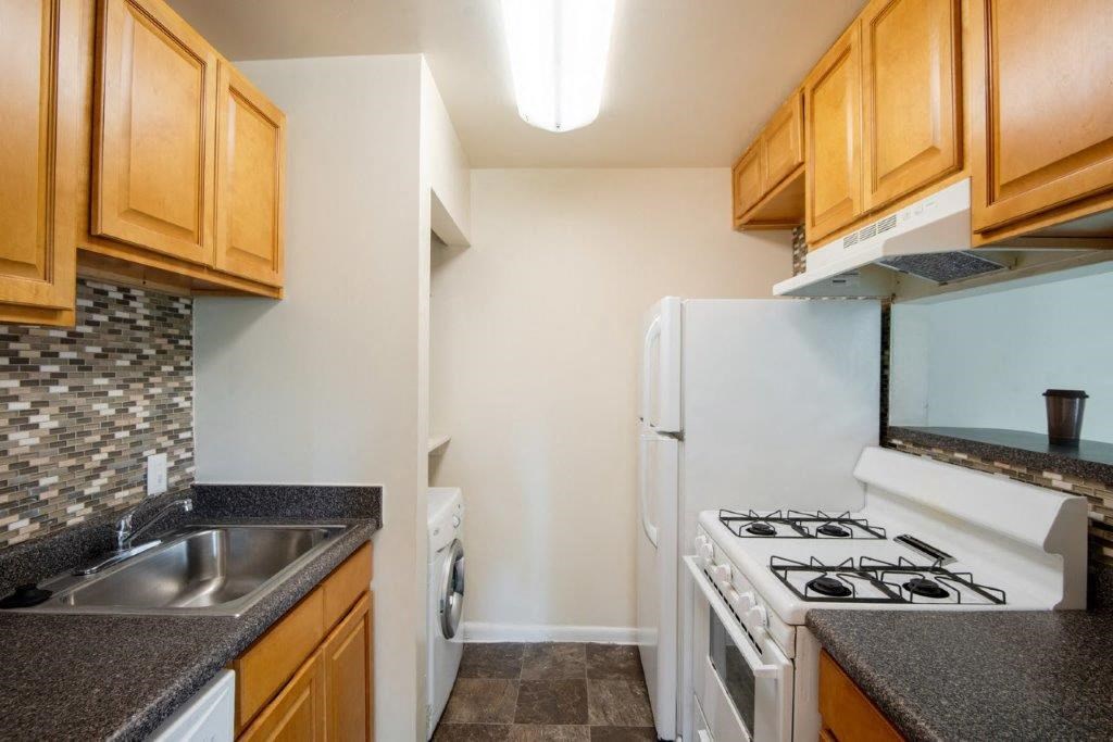 a kitchen with a stove refrigerator and sink