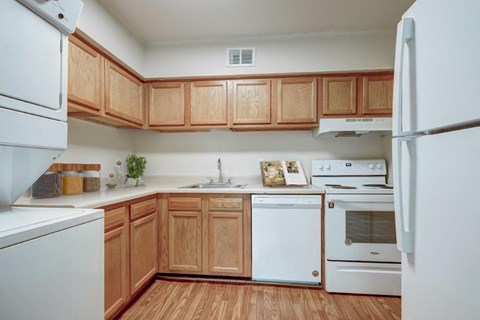 a kitchen with white appliances and wooden cabinets