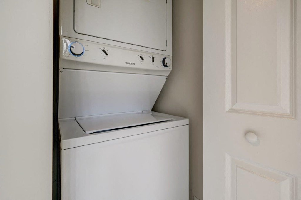 a white washer and dryer in a closet next to a door