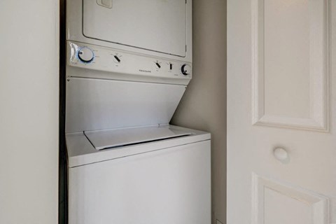 a white washer and dryer in a closet next to a door
