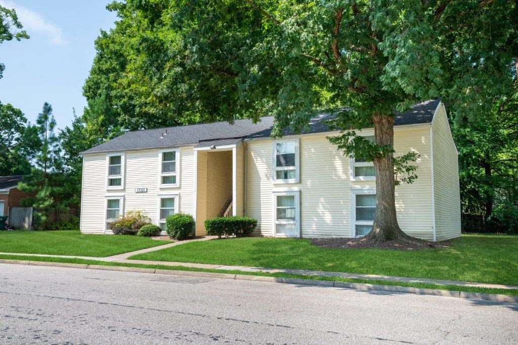 a white house with a tree in front of it