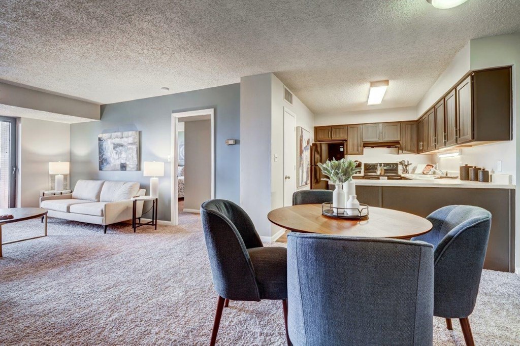 a living room and kitchen with a table and chairs