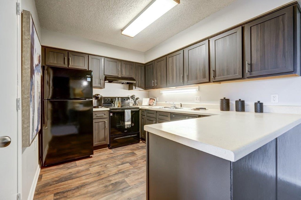 a kitchen with a white counter top and black appliances