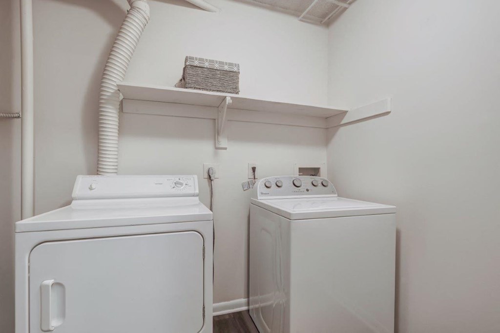a white laundry room with two washes and a dryer