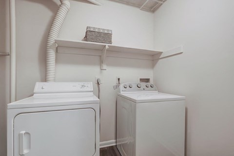 a white laundry room with two washes and a dryer