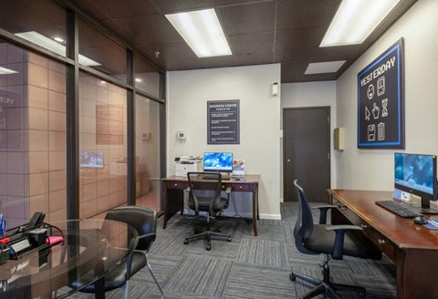a conference room with desks and chairs and a computer