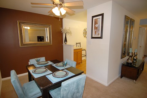 A brown dining room with a table set for four.