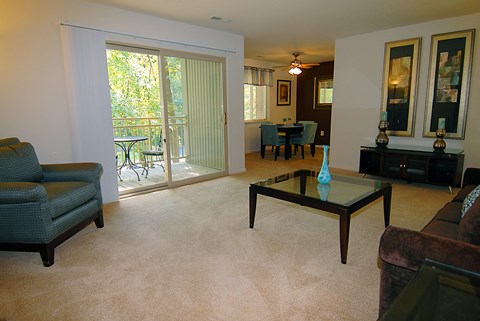 A living room with a glass table and a couch.