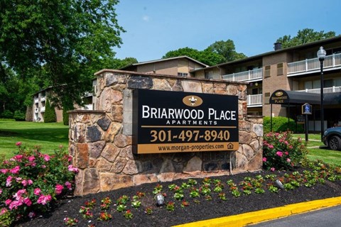 a stone sign in front of an apartment building