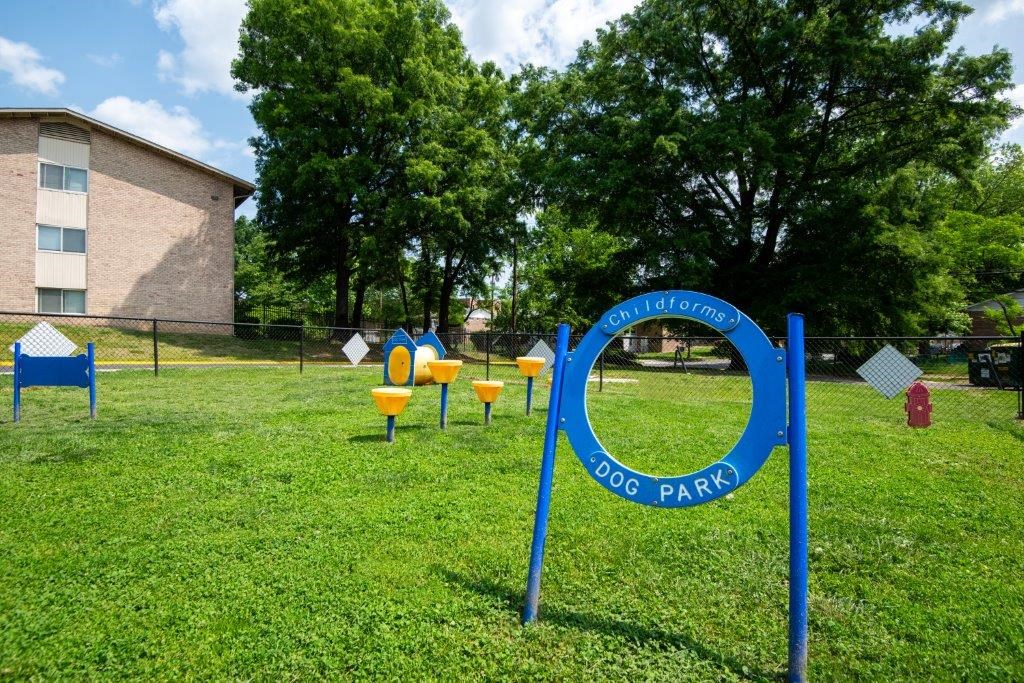 a park with a playground and a blue park sign