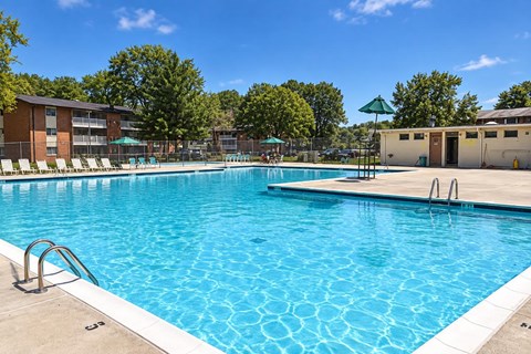A large swimming pool with a blue tiled edge and a diving board.