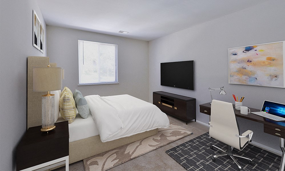 a bedroom with a bed and a desk and a television