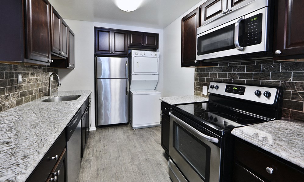 a kitchen with stainless steel appliances and marble counter tops