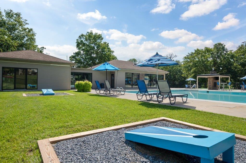 a backyard with a pool and a blue ping pong table