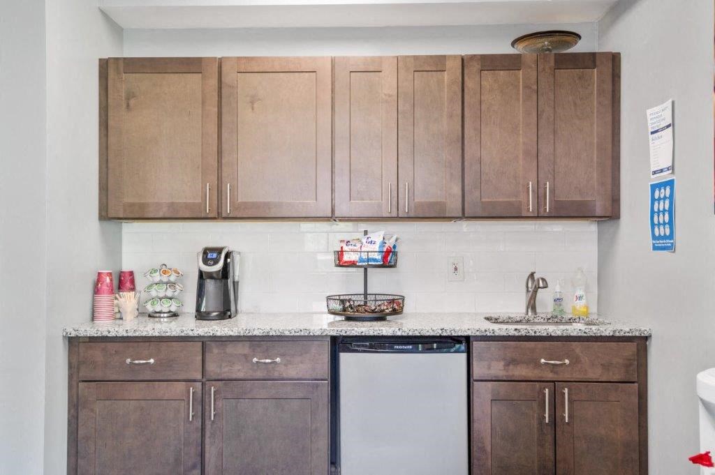 a small kitchen with wooden cabinets and a dishwasher