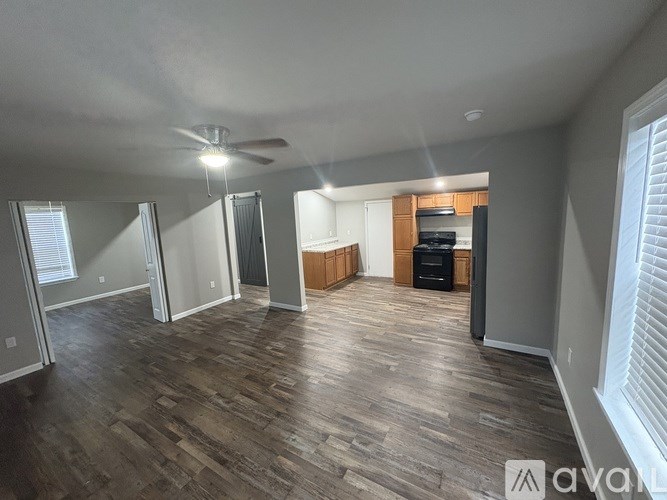 A spacious living room with wood flooring and a ceiling fan.