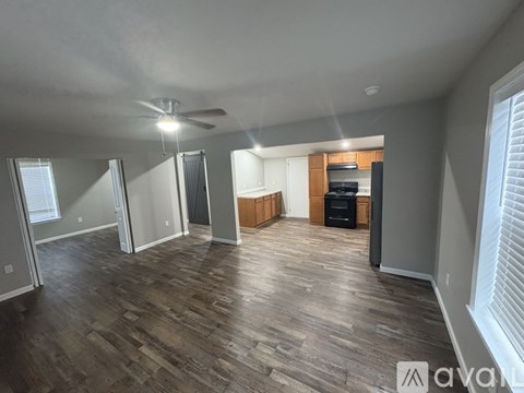 A spacious living room with wood flooring and a ceiling fan.