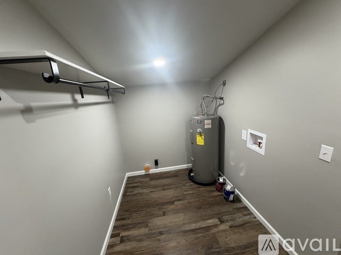 A room with a wood floor and a wall-mounted heater.