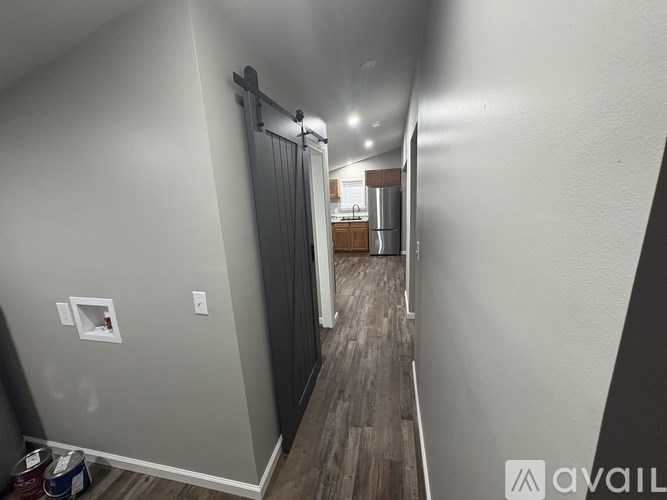 A hallway with a sliding door and a light switch on the wall.