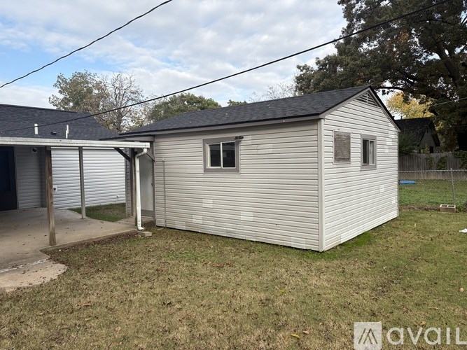 A small house with a grey roof and a grey garage door.