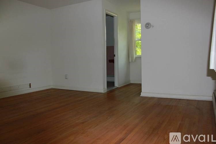 A room with wooden flooring and white walls.