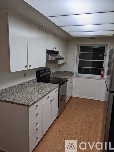 A kitchen with white cabinets and a granite countertop.