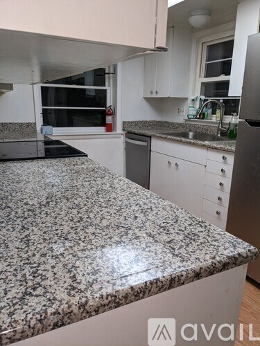 A kitchen with granite countertops and white cabinets.