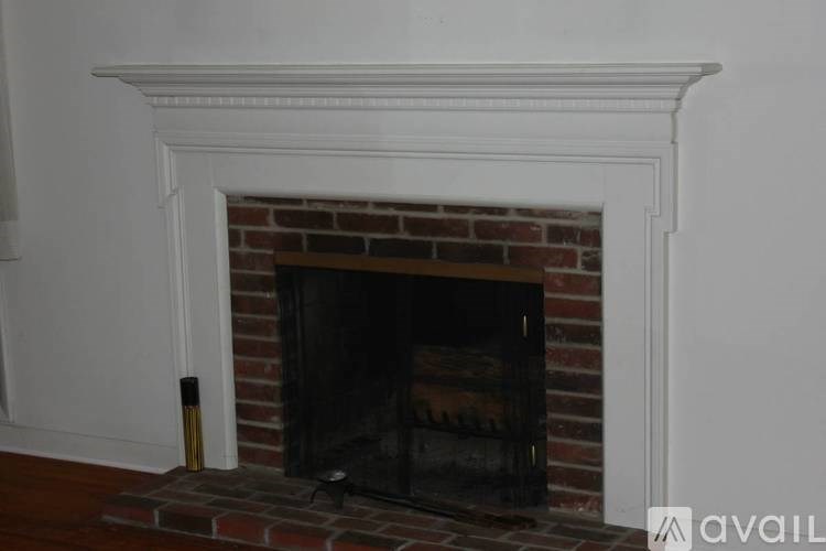 A fireplace with a white mantle and a brick interior.