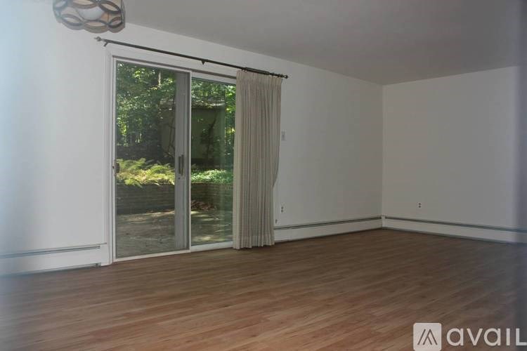 A room with a sliding glass door leading to a garden.