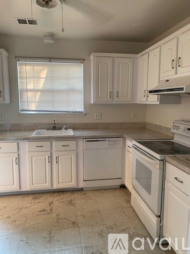 A kitchen with white cabinets and appliances.