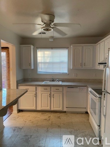 A kitchen with white appliances and cabinets.
