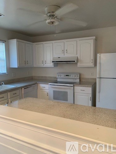 A kitchen with white cabinets and appliances.