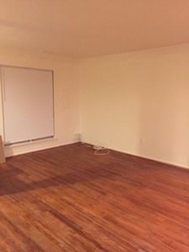 A room with a whiteboard and wooden flooring.