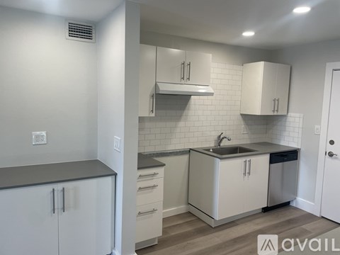 A kitchen with white cabinets and a sink.