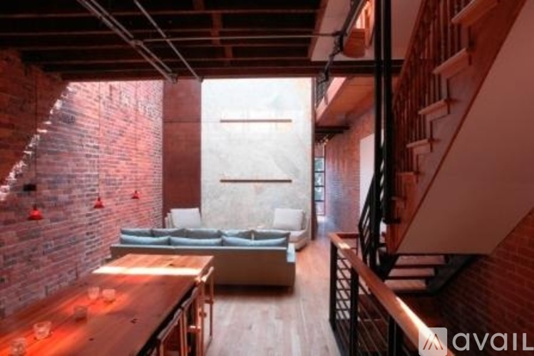 A living room with a couch and a brick wall.