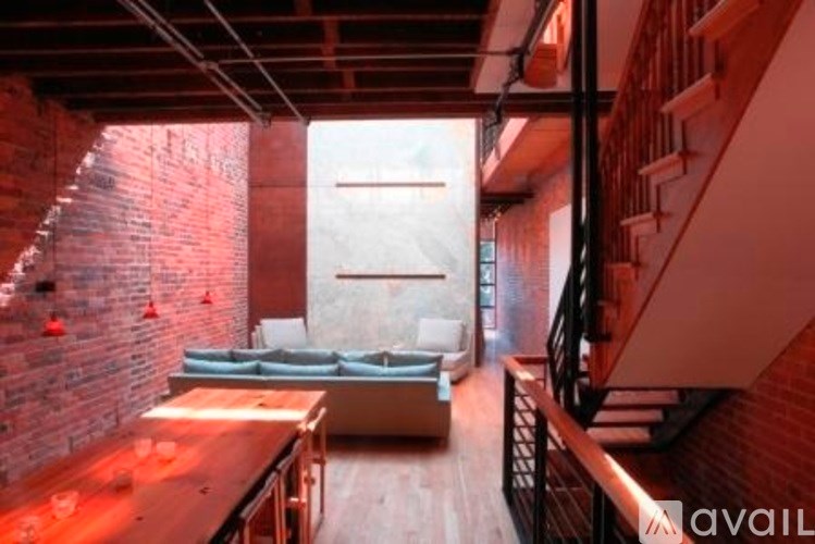 A living room with a couch and a brick wall.